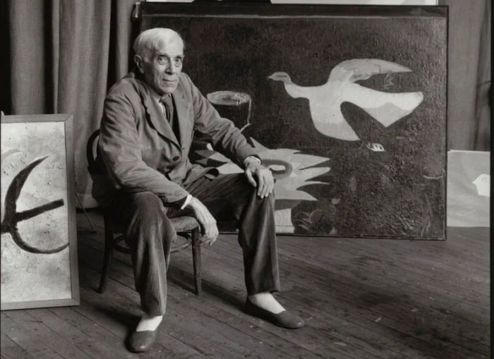 Sedící Georges Braque před svým dílem.