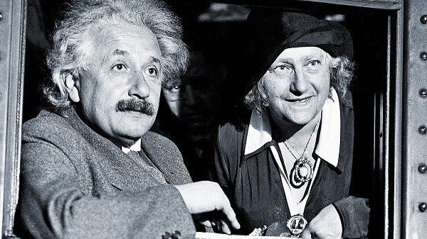 Albert Einstein se svou ženou vykukující z okna vozu.