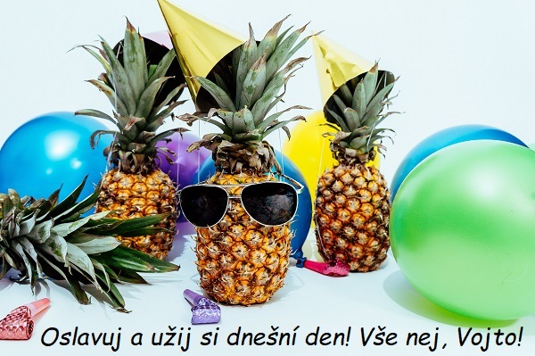 Ananas se slunečními brýlemi a narozeninovou čepičkou, obklopený balónky s přáním k svátku Vojtěchovi.