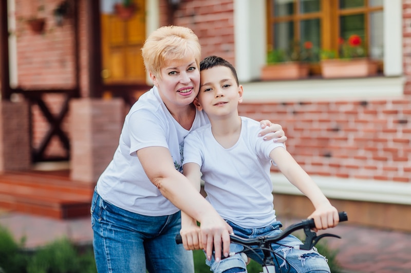 Sympatická maminka se synem, který jede na kole.