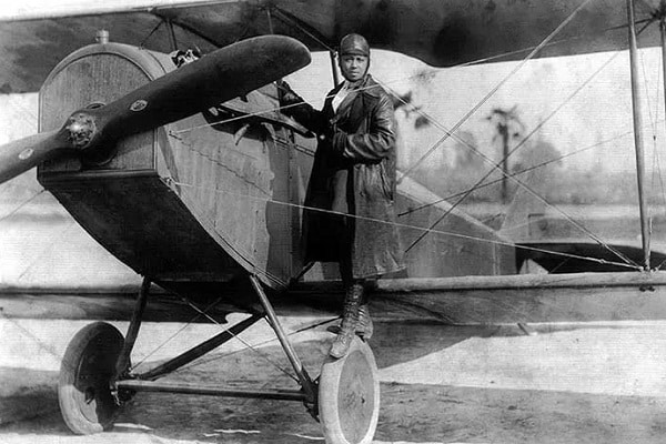 Bessie Coleman stojící na podvozku letadla