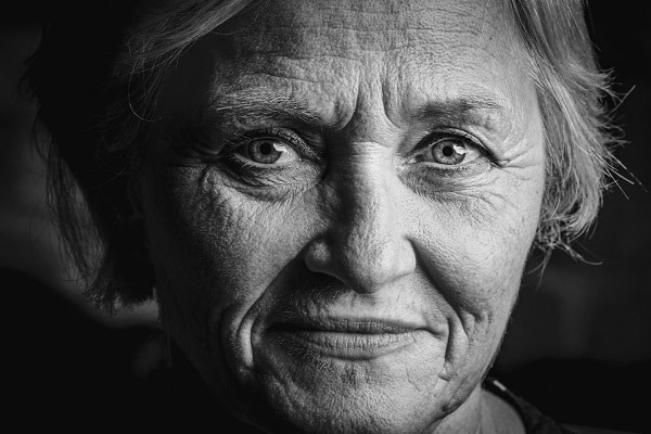 Černobílá fotografie obličeje staré usmívající se ženy