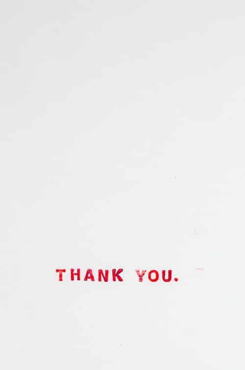 Červený nápis "thank you" na bílém pozadí.