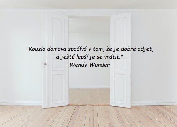 Bílé otevřené dveře v prázdném bytě s citátem o domově od Wendy Wunder.