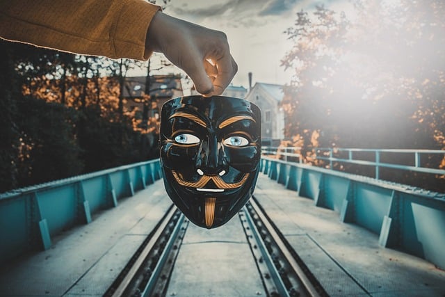 Člověk držící masku nad železnicí.