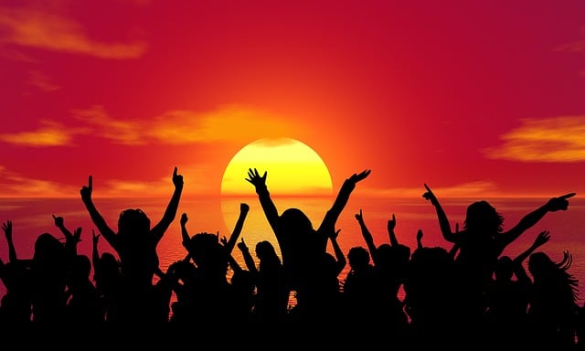 Oslavující lidé při západu slunce.