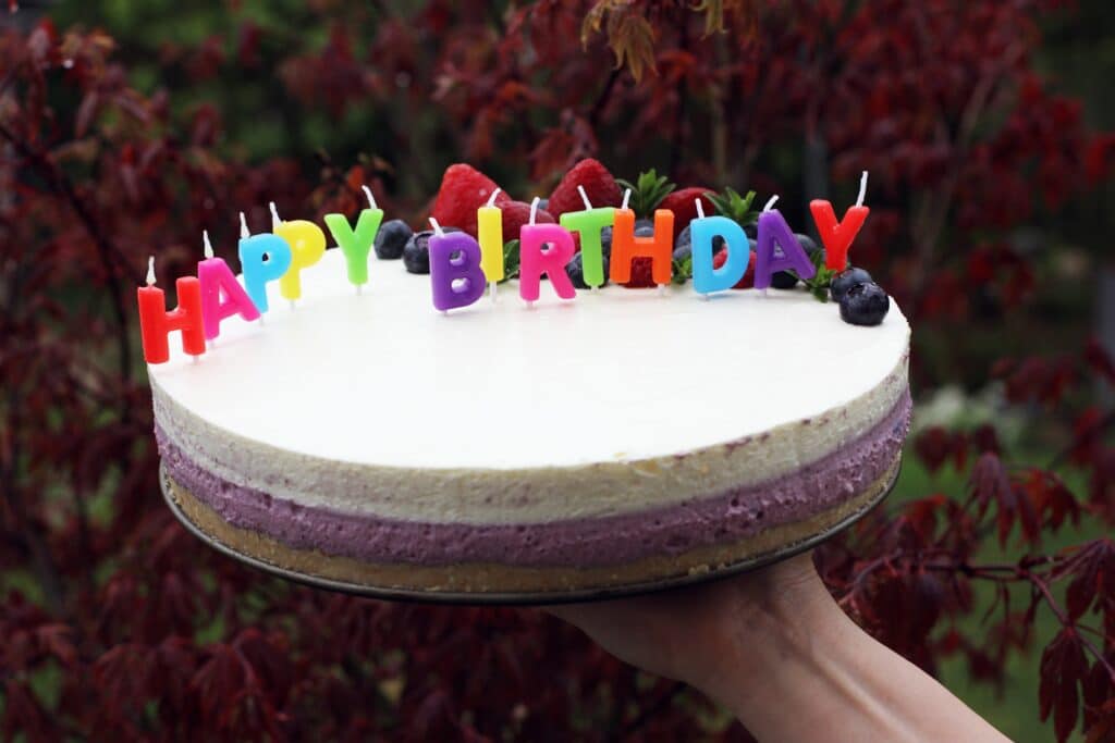dort se svíčkami, které tvoří text: Happy Birthday
