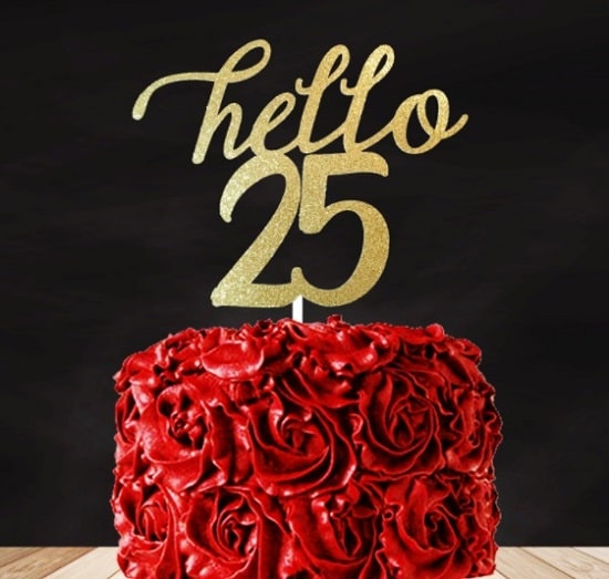 Narozeninový dort z červených růží se zlatým nápisem "Hello 25" na černém pozadí. 