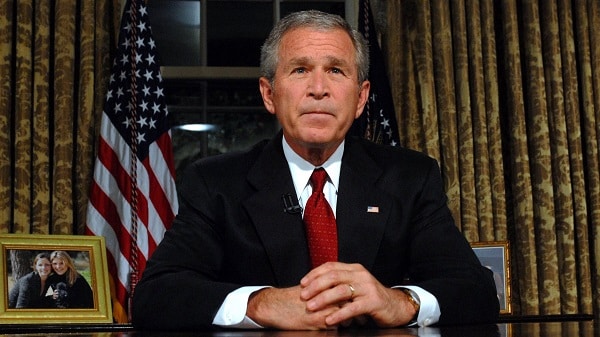 George W. Bush sedící za stolem