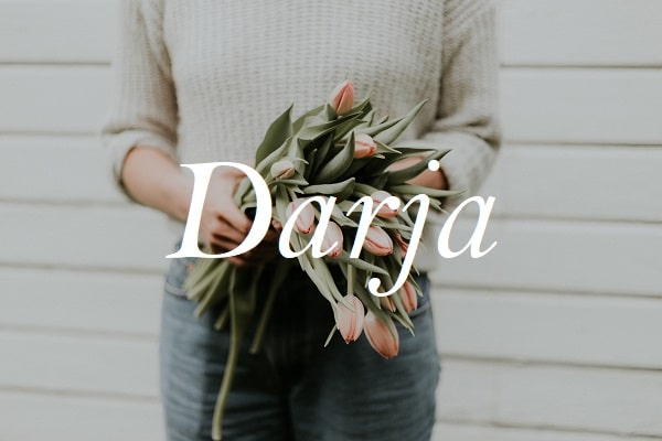 Jméno Darja na pozadí fotografie ženy držící kytici tulipánů.