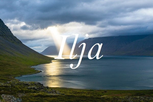 Jméno Ilja na pozadí fotografie jezera se slunečními paprsky prosvítajícími skrze zamračené nebe.