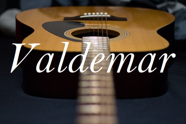 Jméno Valdemar na pozadí fotografie ležící kytary.