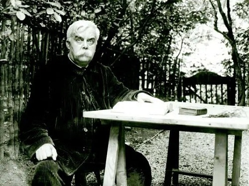 Léon Bloy sedící na zahradě u stolu