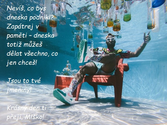 Muž ve slunečních brýlích, sedící na křesle v bazéně pod vodou s plovoucími láhvemi s alkoholem a přáním krásného svátečního dnu Miškovi.