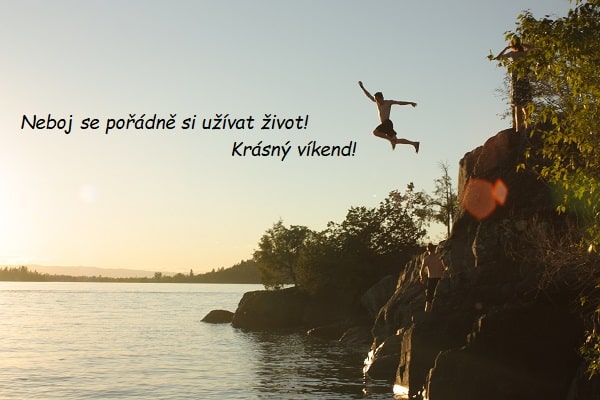 Muž skákající ze skály do vody při západu slunce s přáním krásného víkendu.