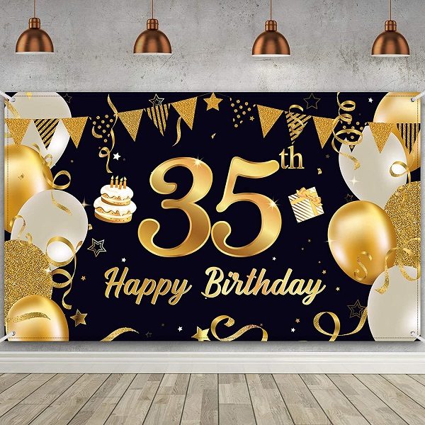 Zlatý nápis "35 Happy birthday" na černém pozadí, zdobeném zlatými balónky, vlaječkami a konfetami. 