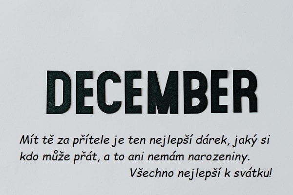 Velký nápis "December" s přáním k svátku na bílém pozadí.