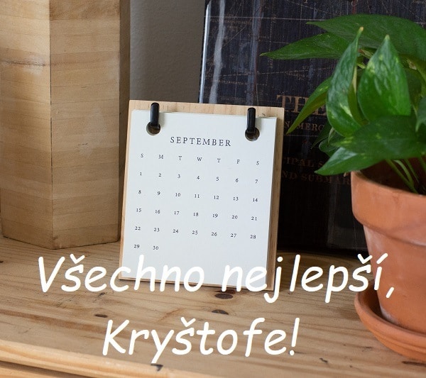 Nápis "Všechno nejlepší, Kryštofe!" na pozadí dřevěné desky s papírovým kalendářem nadepsaným "September".
