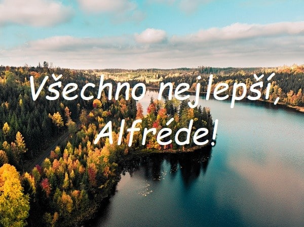 Nápis "Všechno nejlepší, Alfréde!" na pozadí široké řeky lemované lesem v podzimních barvách.
