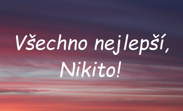 Nápis "Všechno nejlepší, Nikito!" na pozadí růžové oblohy při západu slunce.