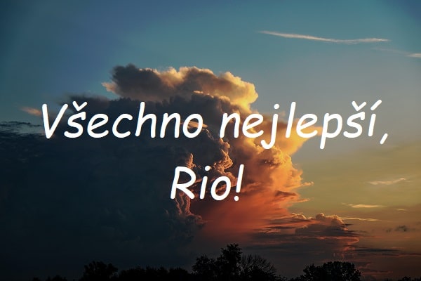 Nápis "Všechno nejlepší, Rio!" na pozadí fotografie s mračny na obloze.