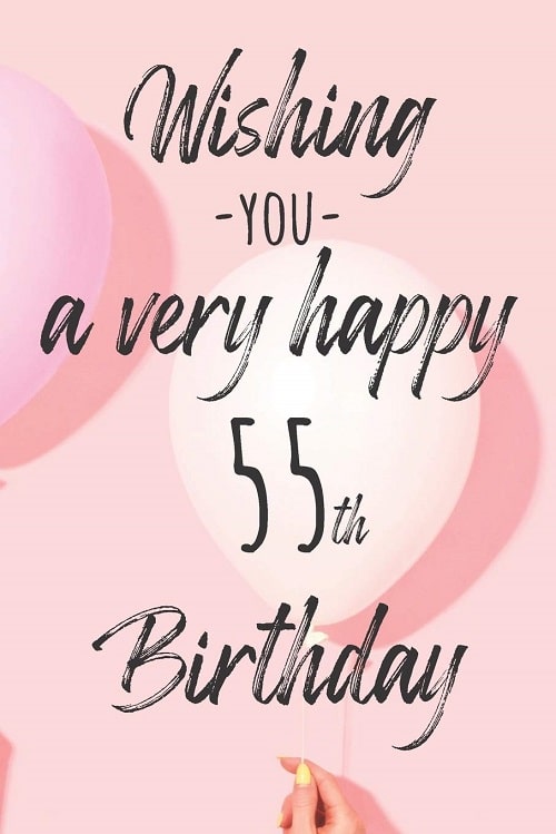 Dámská ruka držící nafukovací balónek s nápisem "Wishing you a very happy 55th birthday". 