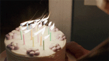 Bílý narozeninový dort se svíčkami. 
