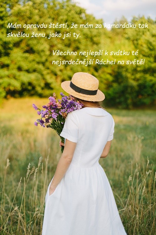 Zády otočená žena v bílých šatech s kloboučkem a kyticí fialových lučních květů, stojící na louce s přáním k svátku Ráchel.