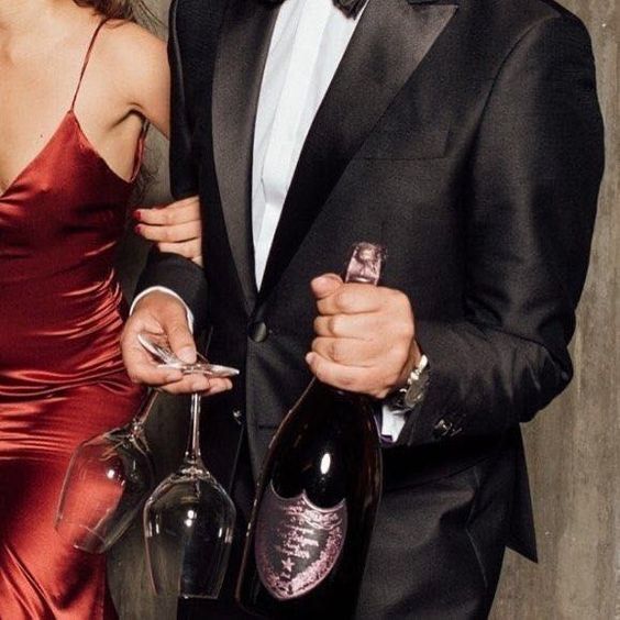 Oslavující pár s šampaňským a skleničkami v ruce. 