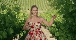 GIF blahopřání žena se sklenicí vína ve vinohradě. 