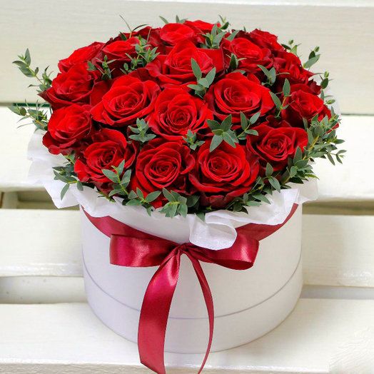 Rudé růže v bílé dárkové krabici s mašlí. 