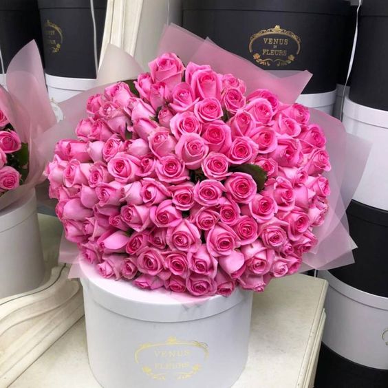 Dárková kytice růžových růží k svátku na bílé krabici. 
