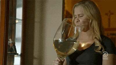 GIF přání k jmeninám s ženou a obří sklenicí na víno.