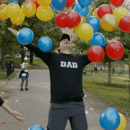 GIF přání k svátku chlap s barevnými balónky. 