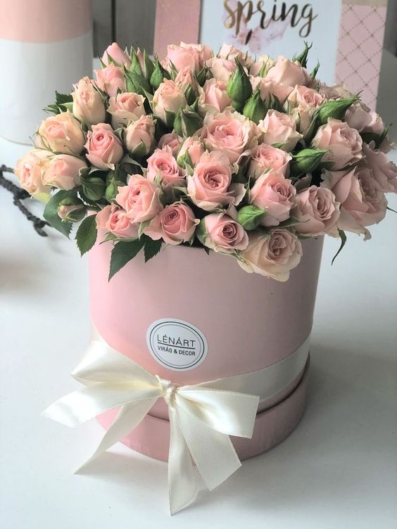 Dárková kytice růží k svátku v růžové dárkové krabici. 
