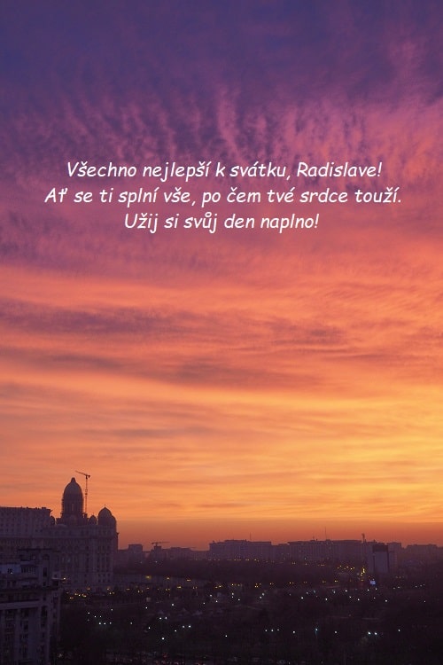 Přání k svátku Radislavovi na pozadí pohledu na město při západu slunce.