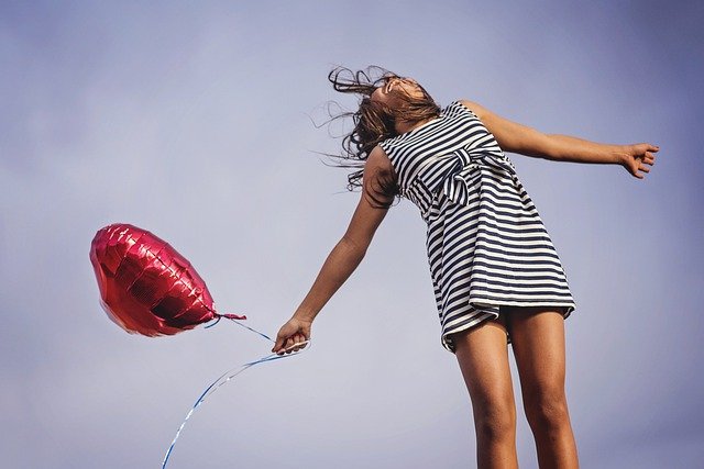 Přání k svátku s dívkou držící balonek.