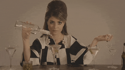 GIF přání k jmeninám holka přelévá skleničku s Martini. 