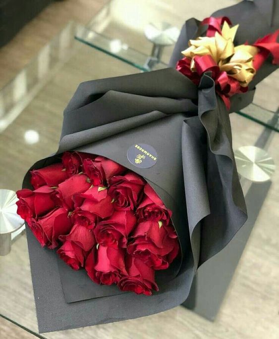 Červené růže k svátku v černém dárkovém papíře. 