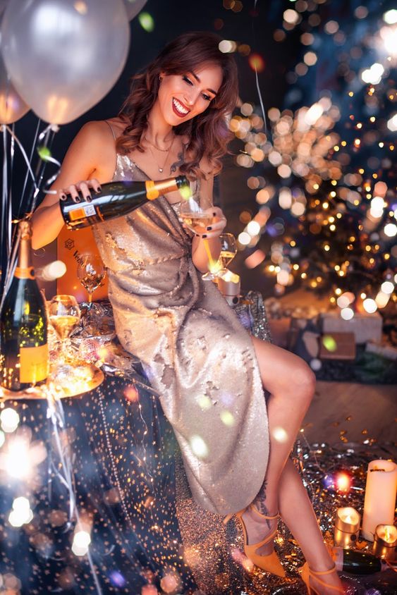 Oslavující holka se skleničkou šampaňského v ruce. 