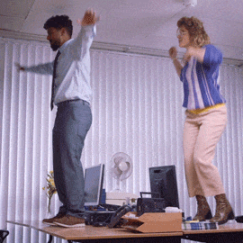 GIF blahopřání k jmeninám pár tančí na stole v kanceláři. 