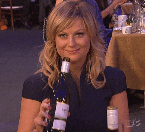 GIF blahopřání k svátku blondýna s flaškou vína v ruce. 