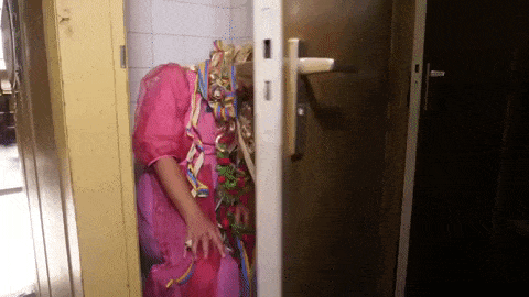 GIF přání k svátku opilý borec v růžových šatech a blond paruce spí na záchodě.  