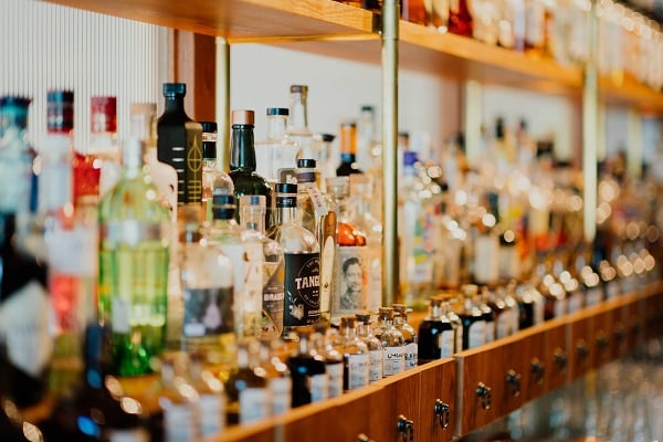 Regál s lahvemi různých druhů alkoholu
