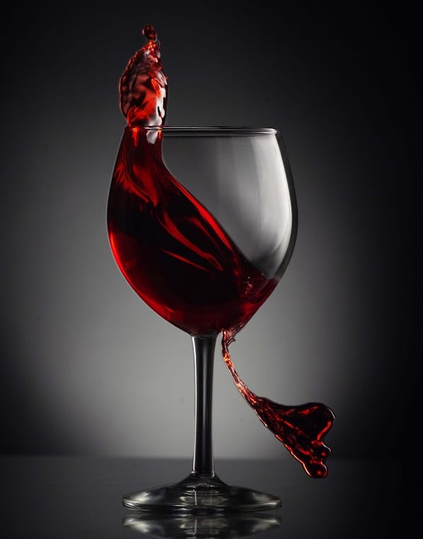 Sklenice s pohybujícím se červeným vínem.
