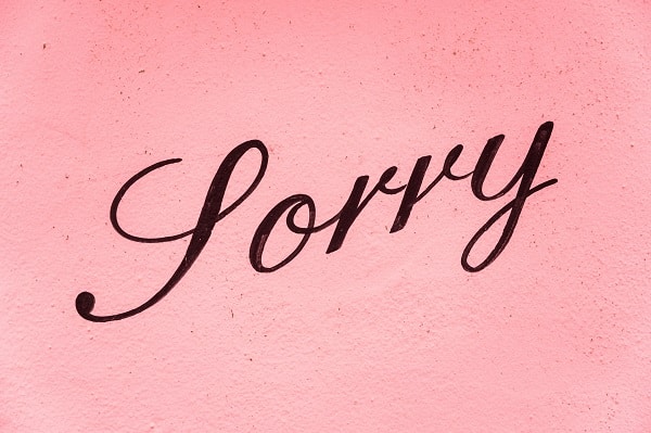 Anglický nápis "Sorry" na růžovém pozadí.