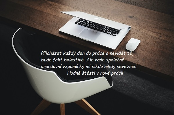 Dřevěný stůl s notebookem, myší a bílou židlí s přáním hodně štěstí v nové práci.