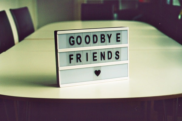 Stůl v zasedací místnosti s tabulí s nápisem "Goodbye friends". 