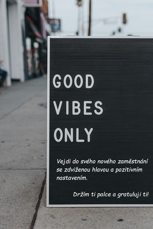 Černá tabule s nápisem "Good vibes only" a s gratulací k novému zaměstnání.