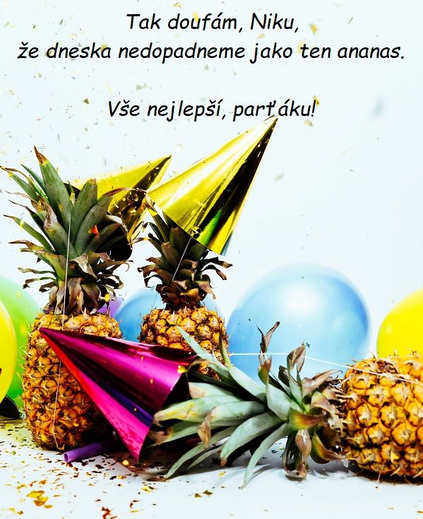 Dva ananasy s narozeninovými čepičkami, před nimiž leží další ananas s narozeninovou čepičkou a s nafukovacími balónky.